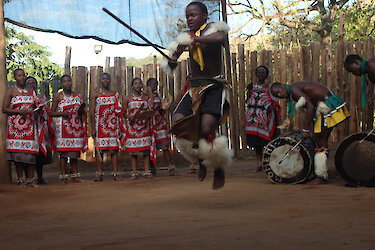 Die Einheimischen singen und tanzen in ihren traditionellen Kleidungen. eSwatini.