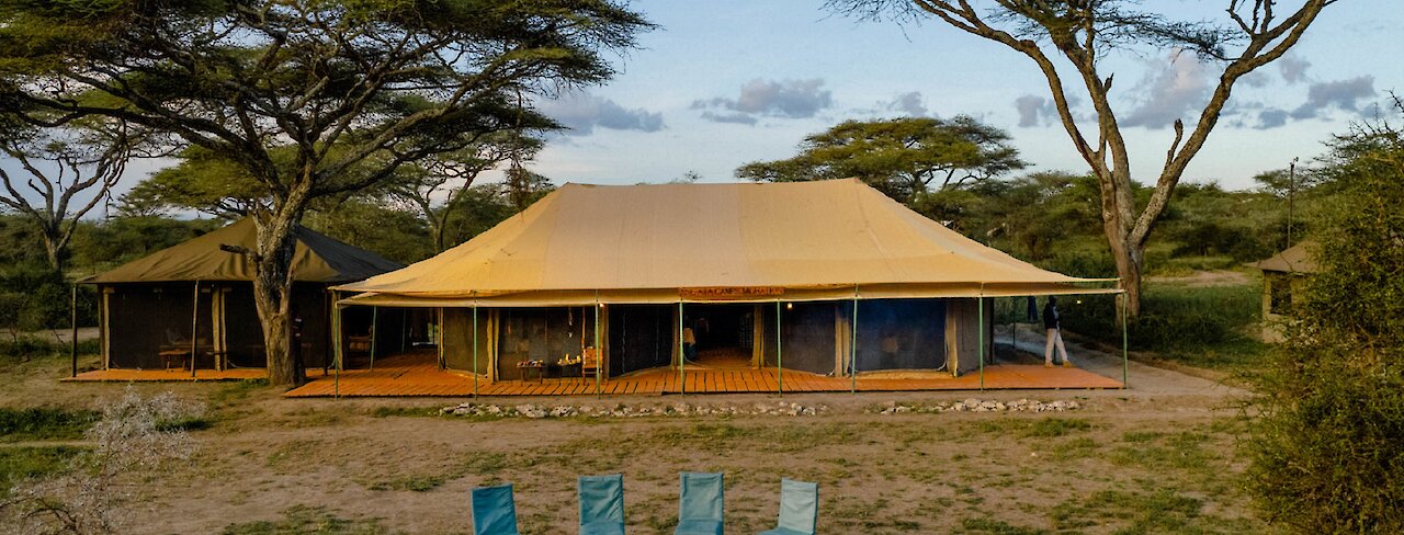 Ausblick auf Zelt und Lagerfeuer im Ang’ata Migration - Ndutu Camp und in Weitsicht