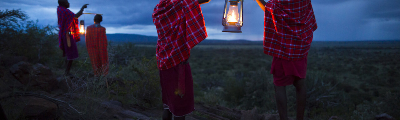 Massai mit Laternen im Zwielicht
