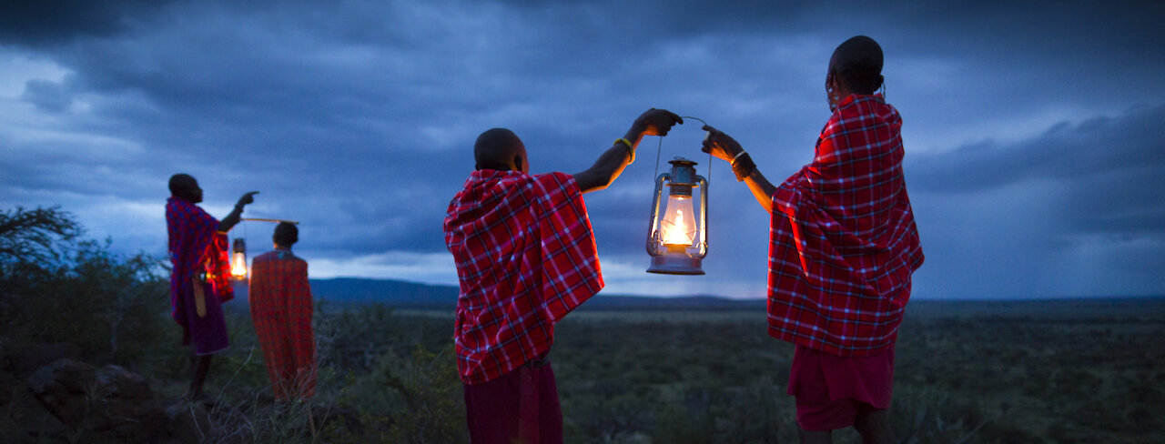 Massai mit Laternen im Zwielicht