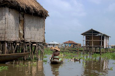 Frau fährt durch die Stelzenstadt Ganvié