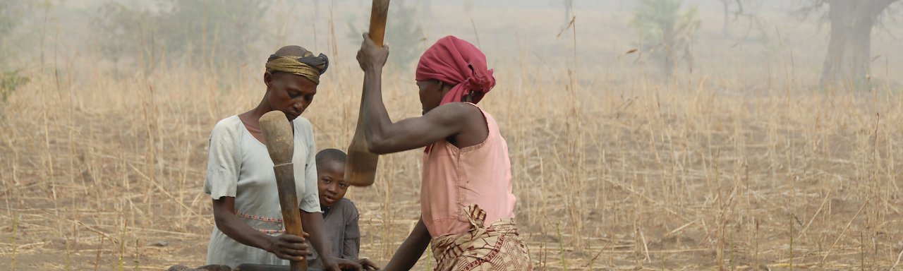 Frauen mit Kind in der Savanne bei ihrer täglichen Arbeit