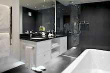 Badezimmer in schwarz und weiß mit Badewanne und Dusch im Grand Roche Hotel