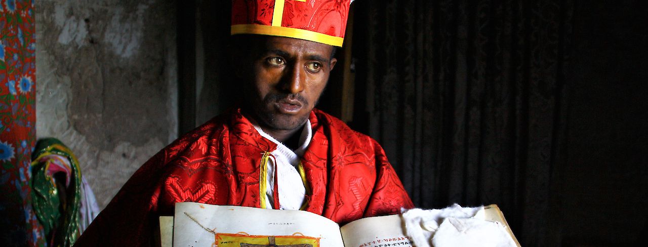 Mönch zeigt historische Bibel in Bergkloster bei Lalibela, Äthiopien