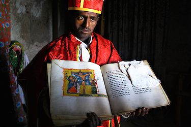 Mönch zeigt historische Bibel in Bergkloster bei Lalibela, Äthiopien
